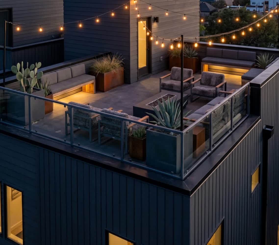 Private roof deck at dusk with lounge seating and string lighting